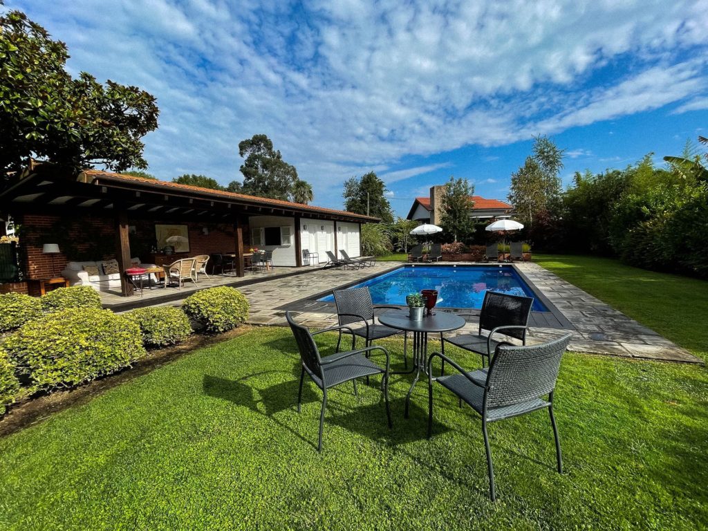 La Casa de Somió - Jardín y mesa con piscina al fondo